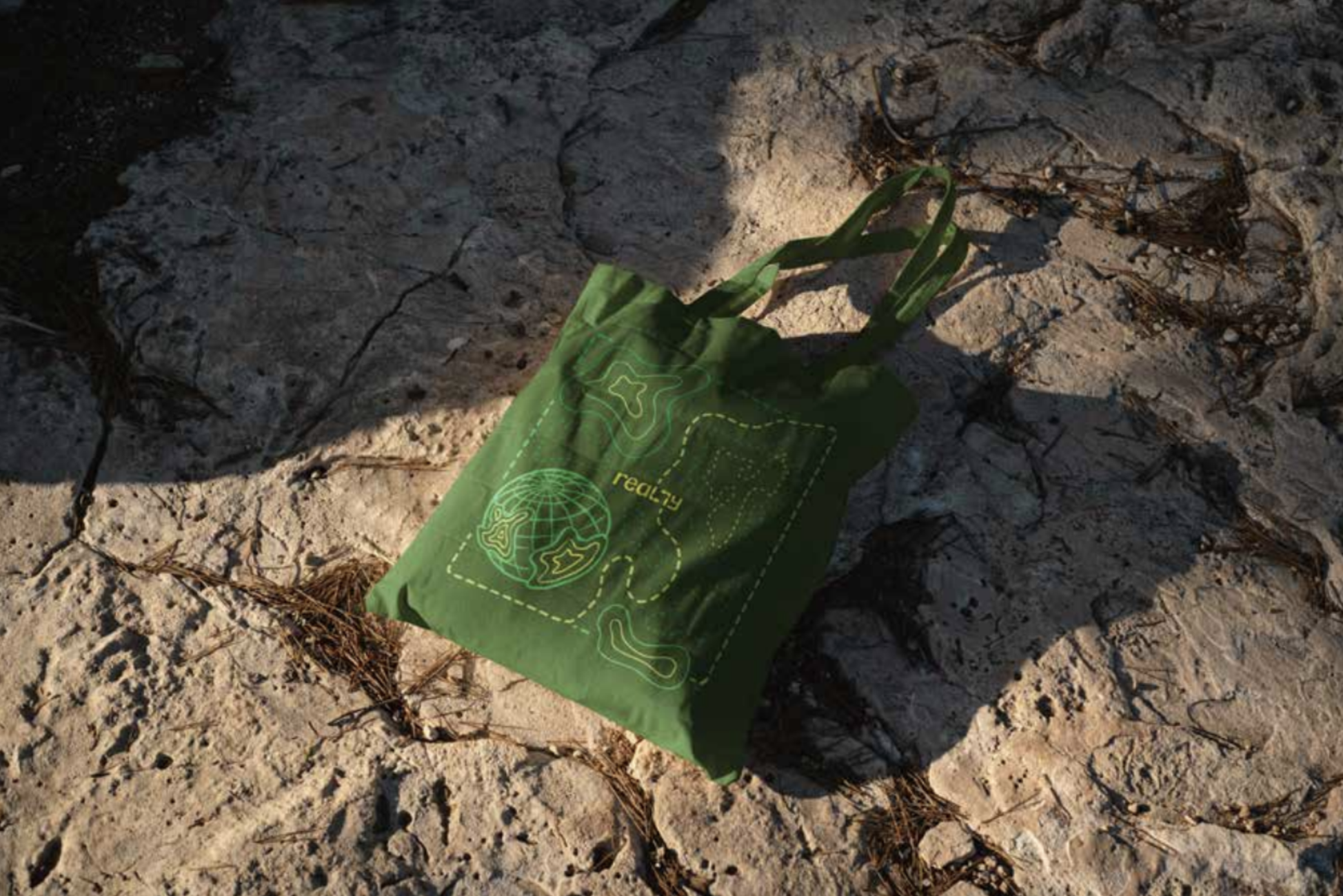 A green tote bag designed for the company Really, depicting topographical contours.